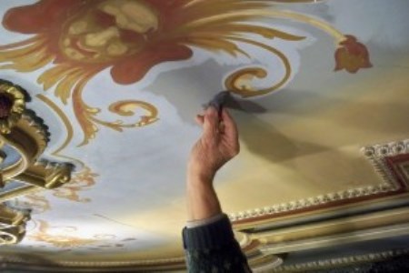 Conservator cleaning drawing room ceiling